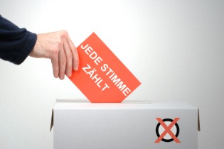 Betriebsratswahl Software Ein Mann wirft einen Wahlzettel in eine Box
